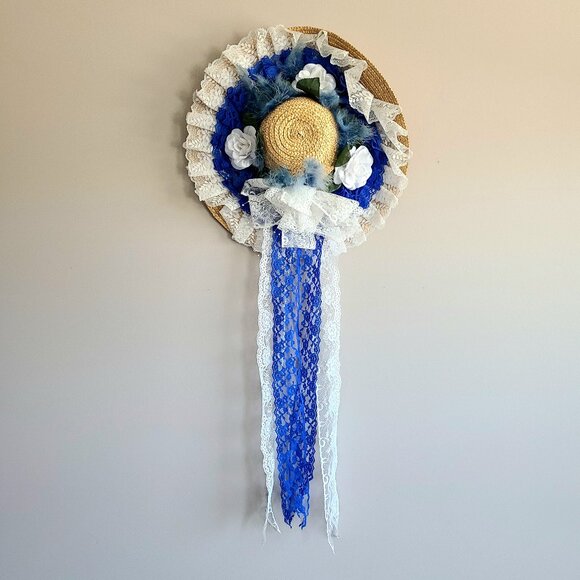 Decorative wreath hat with blue and white ribbons and floral design. - Picture 1 of 6